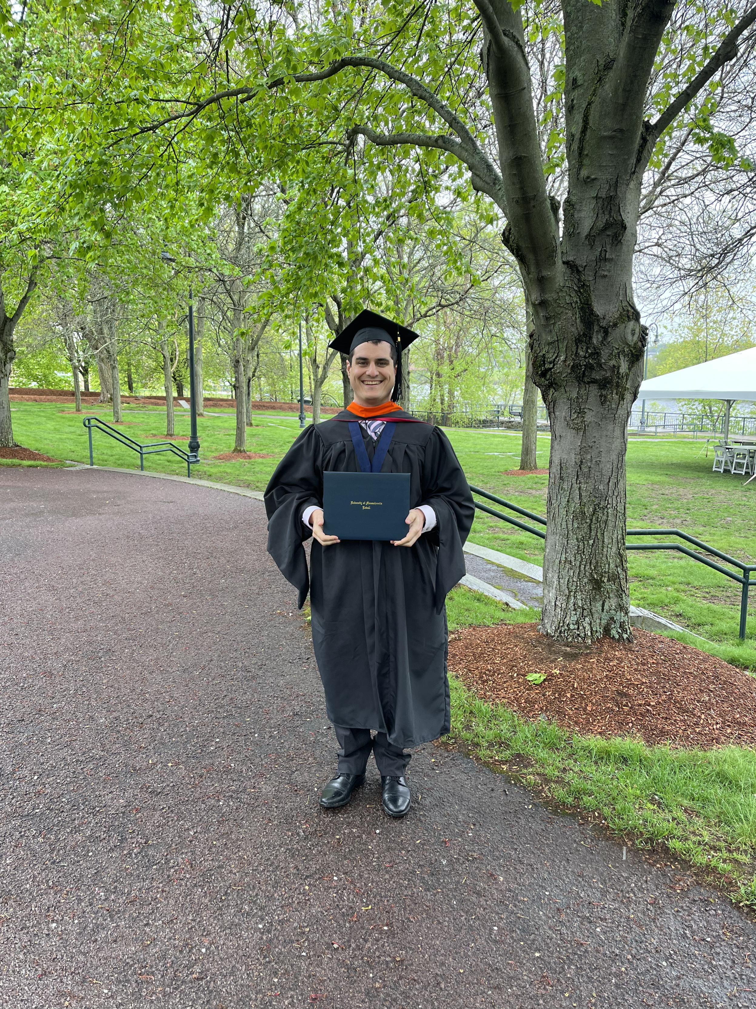 Me in my masters regalia (orange hood) holding my newly conferred degree in computer engineering